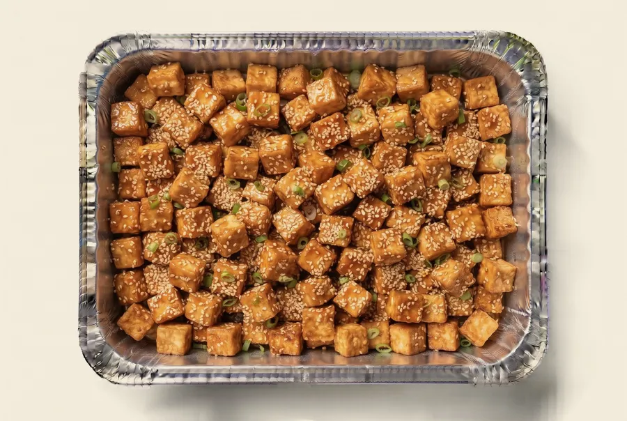 golden sesame tofu catering tray — crispy tofu in a sticky glaze with green onion and sesame, the vegan option for twin cities catering