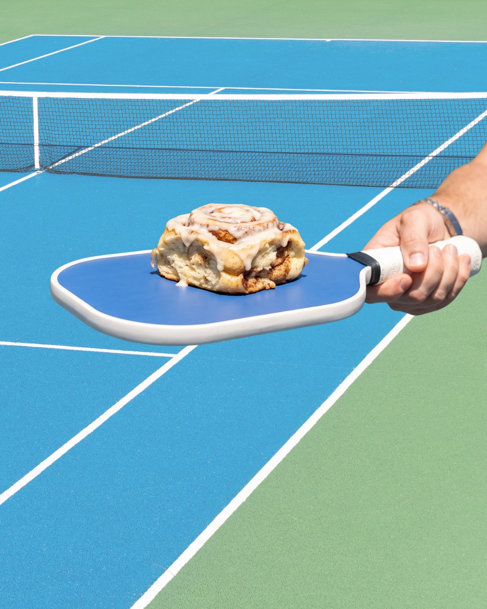 cinnamon roll served on a pickleball paddle